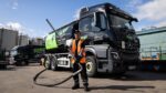 An employee stands in front of a Slicker Recycling Tanker