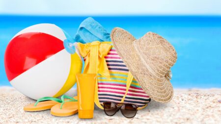 Beach ball, sun hat, flip flops and sunglasses on the beach