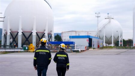 Workers with Gizil jackets outside fuel refinery